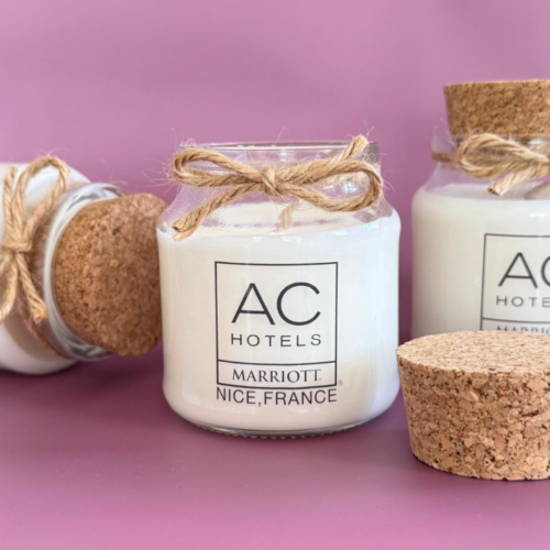 Bougie personnalisée avec logo d'hôtel dans un pot en verre transparent, idéale comme cadeau client et goodie d'entreprise.