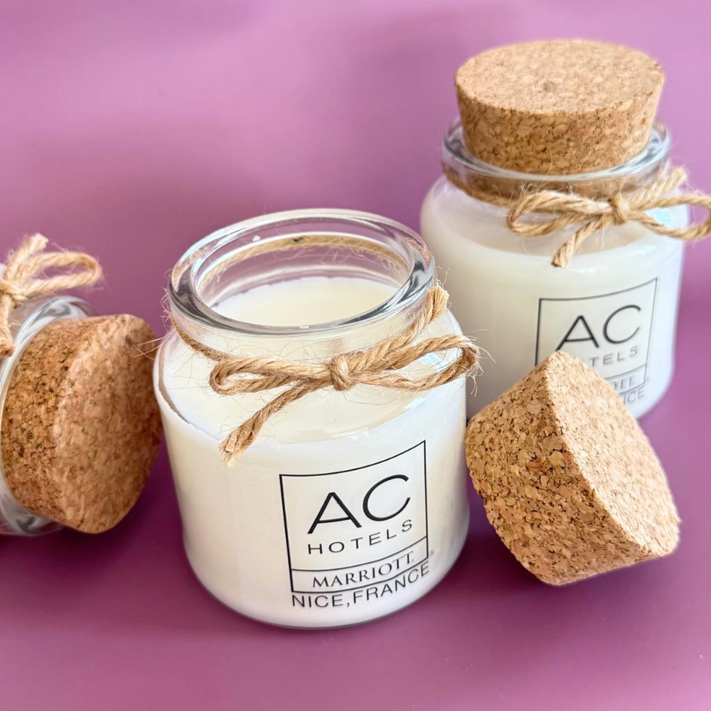 Bougies personnalisées avec logo d'hôtel dans un pot en verre transparent, bouchon en liège et cordelette en jute.