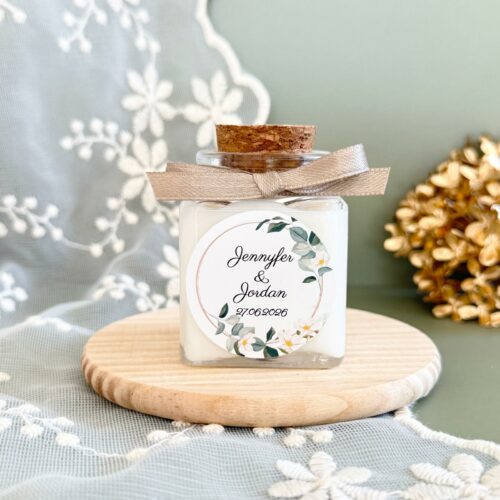 Bougie carrée personnalisée pour mariage avec étiquette florale et bouchon en liège.